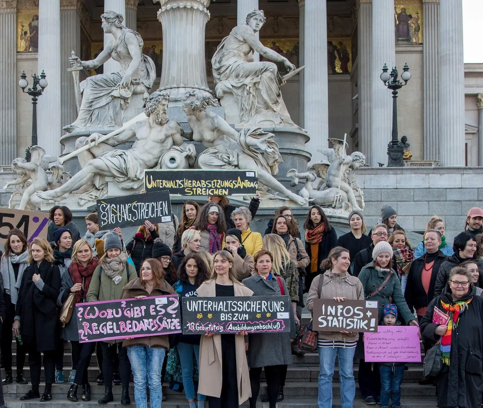 Demonstration von Alleinerzieherinnen mit Schildern vor dem Pallas-Athene-Brunnen am Wiener Parlament