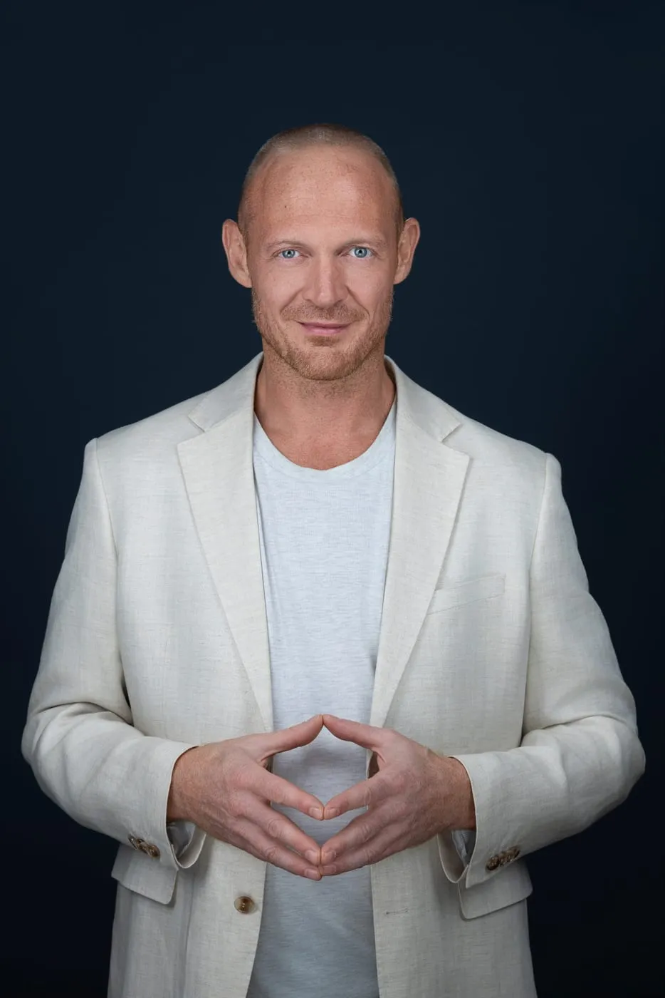 Bernd Stollwitzer im hellen Sakko vor dunkelblauem Hintergrund